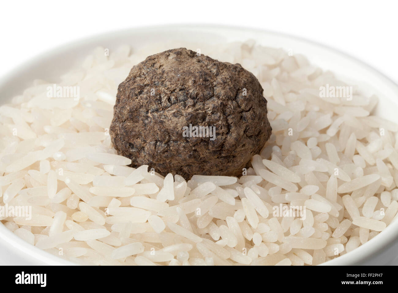 Tasse roher Reis mit frischen schwarzen Wintertrüffel Trüffel hautnah auf weißem Hintergrund Stockfoto