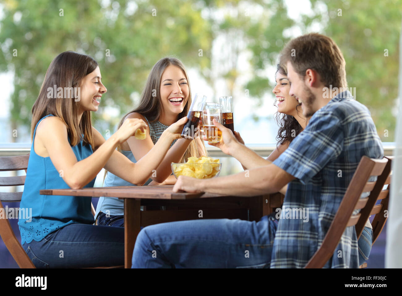 Gruppe von 4 glückliche Freunde in einem Hotel oder nach Hause Terrasse Toasten Stockfoto