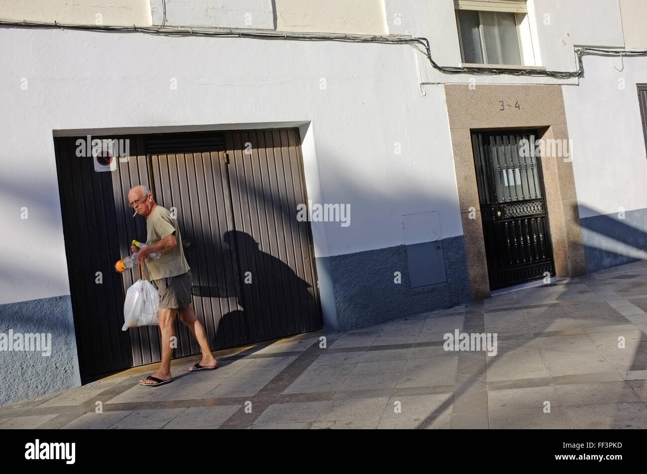 Ein Mann in Cadiz, Spanien öffnet seine Garage. Stockfoto