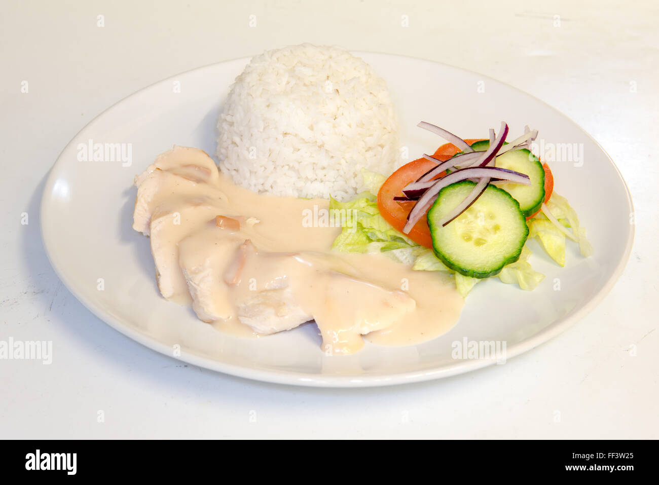 Chicken Dinner mit Reis garniert mit weißer Soße Stockfoto