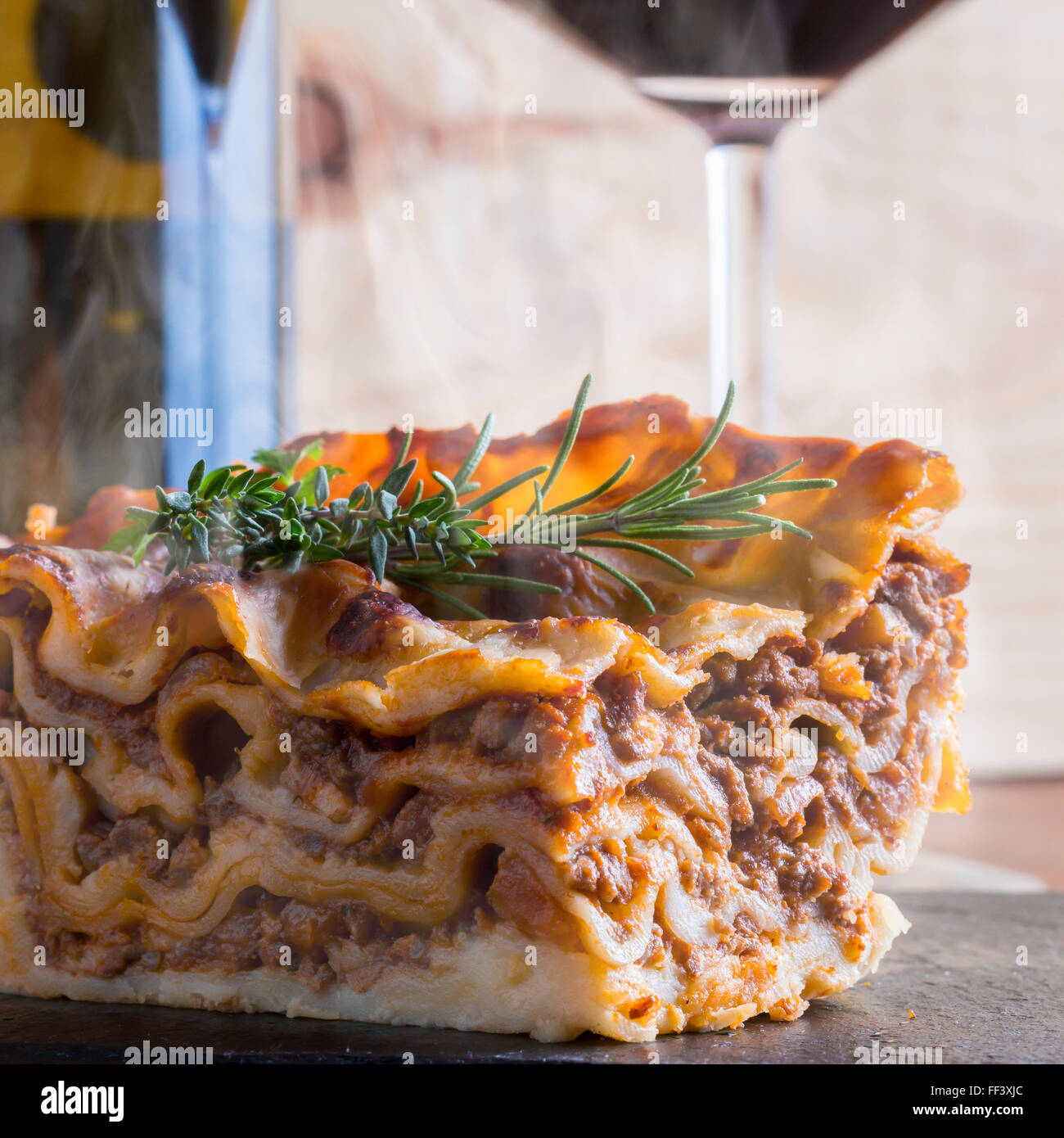 heiß dampfende Lasagne mit Rotwein auf Schiefer und Holz Tisch Stockfoto