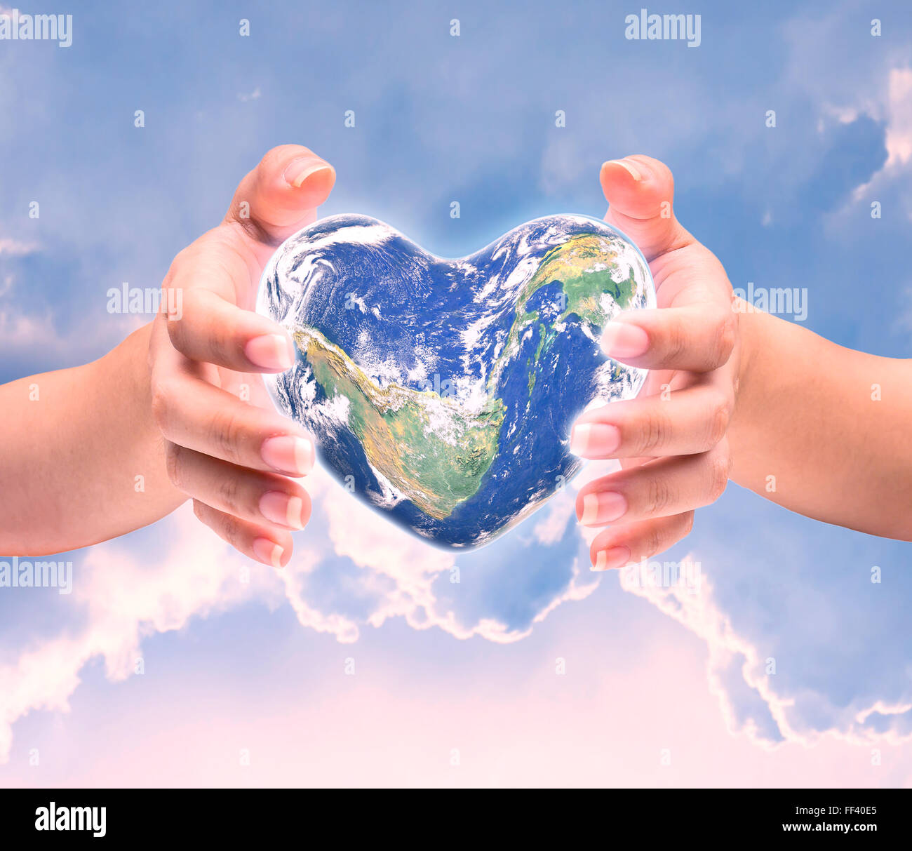 Welt in Herzform mit über Frauen, die menschlichen Hände auf unscharf natürlichen Hintergrund blau Cyan Türkis Baum und Himmel: Welt-Herz-Hea Stockfoto