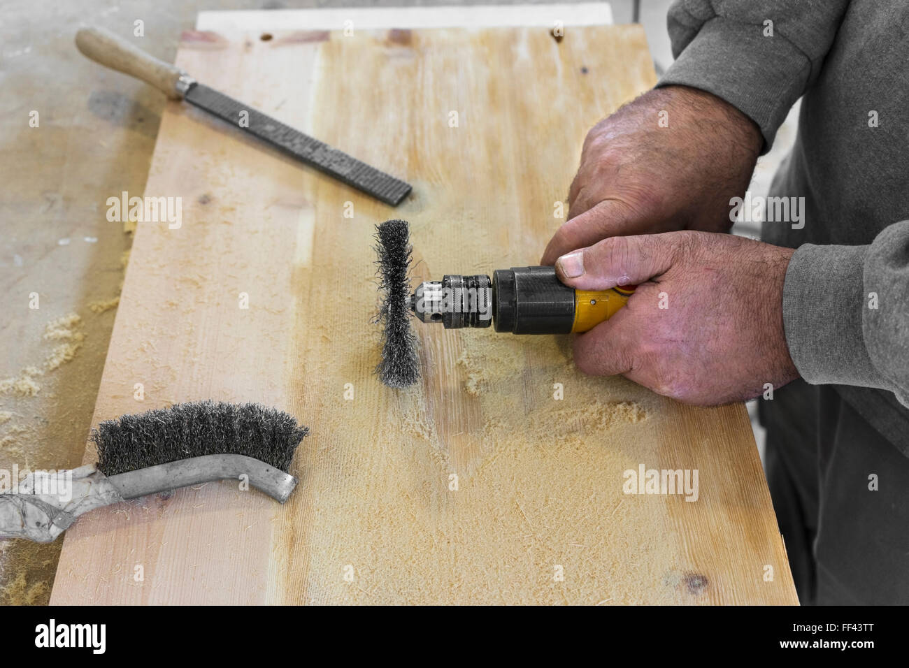 Hände Mann mit elektrischen rotierenden Bürste Metallscheibe ein Stück Holz Schleifen Stockfoto
