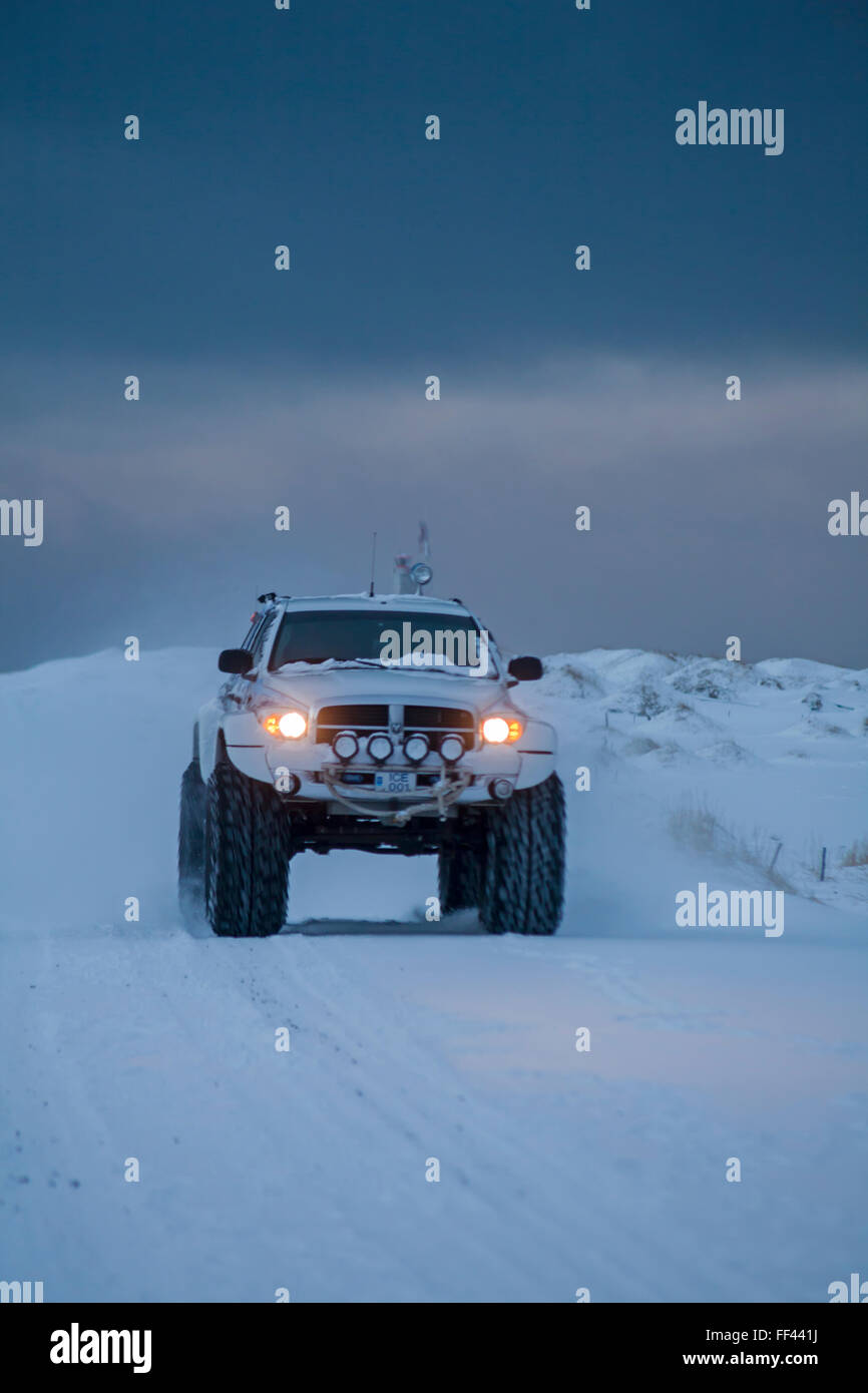 SUV fahren entlang der Straße im Schnee in Island im Januar Stockfoto