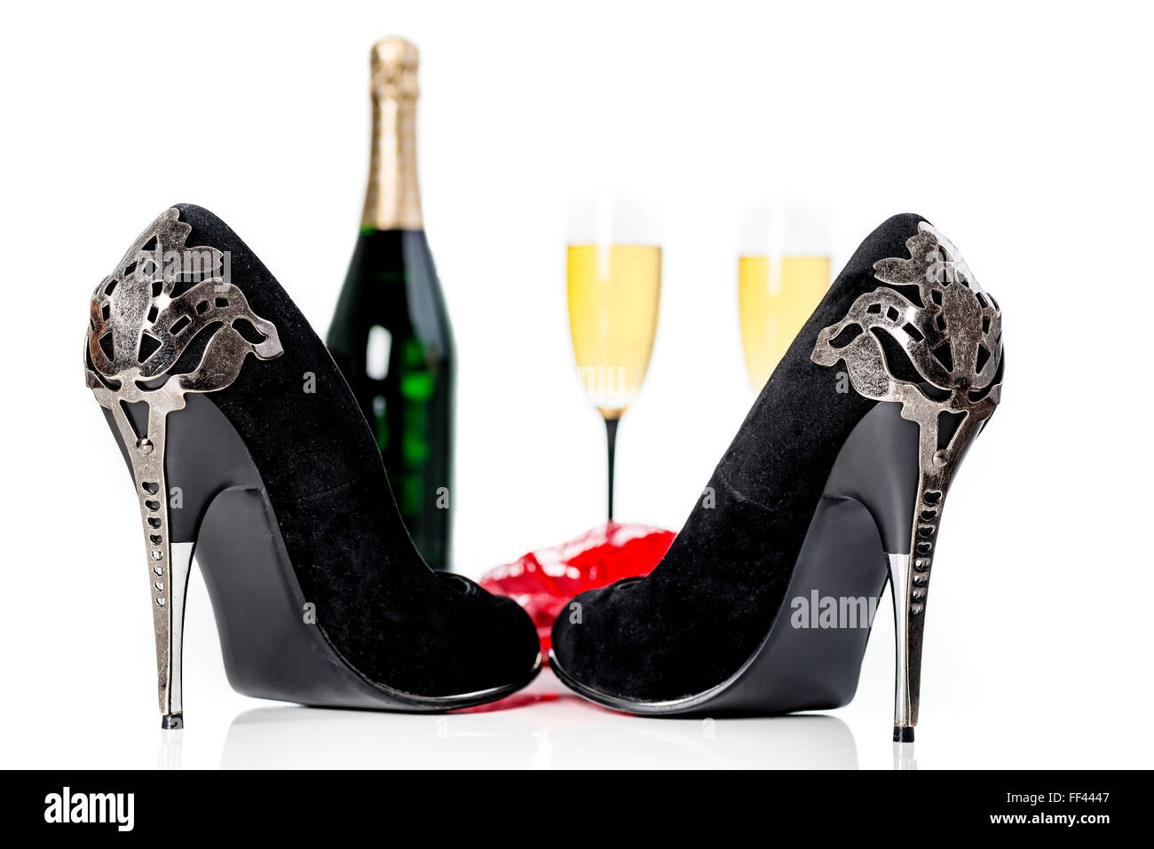 Schwarze High Heels, rote Dessous, Champagner und Gläser auf weißen reflektierenden Hintergrund. Valentinstag, Liebe Konzept. Stockfoto