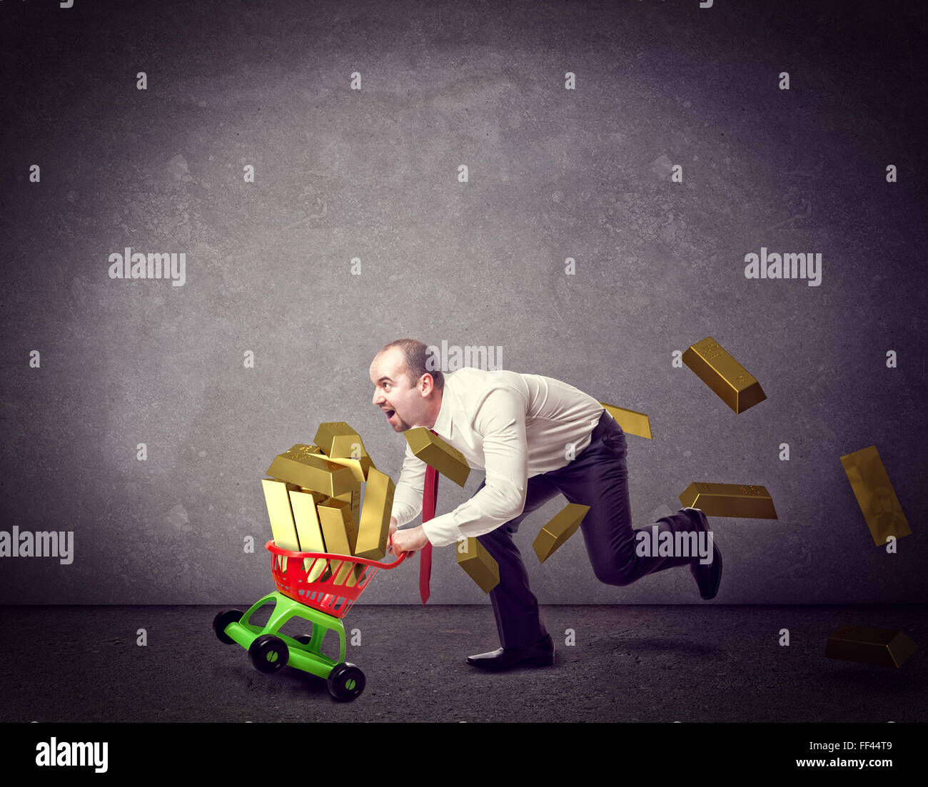 Mann mit shopping Troller Spielzeug und goldenen Barren Stockfoto