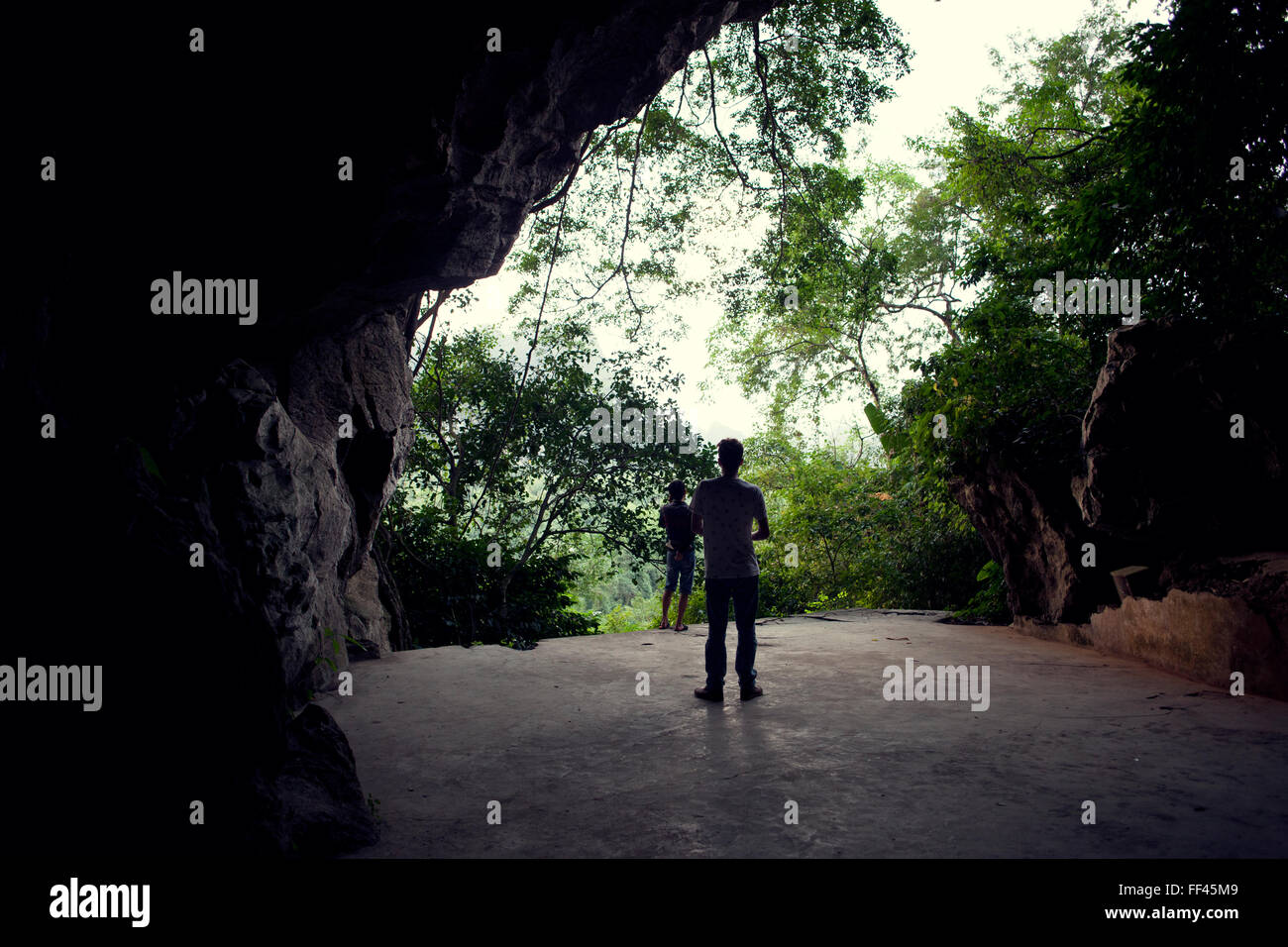 Silhouetten von zwei Menschen vor einem militärischen Höhle auf Cat Ba Insel, Vietnam. Stockfoto