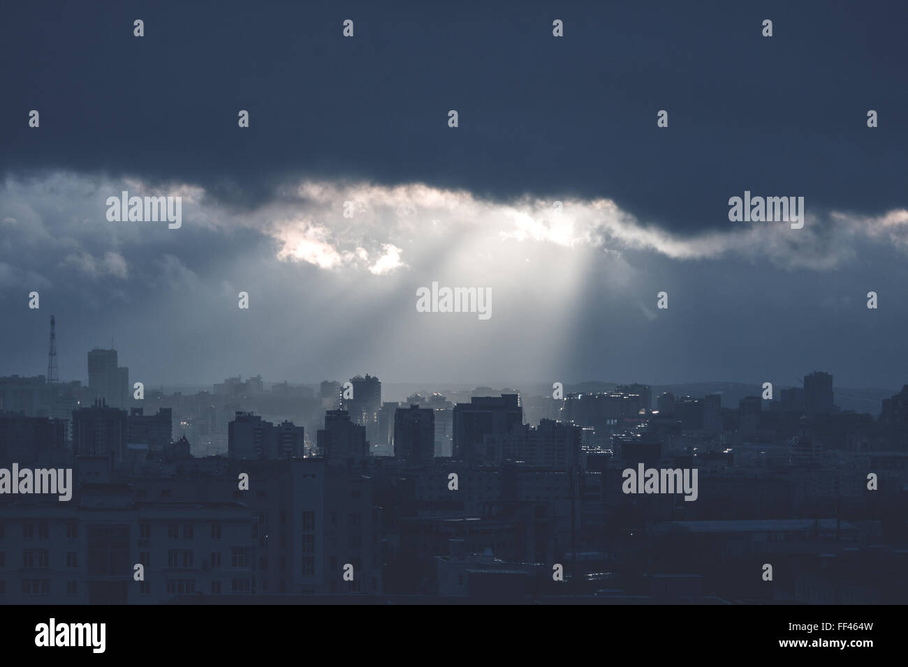 Monochrome Landschaft mit Gewitterhimmel, Strahlen der Sonnenlicht und Industriestadt. Bild mit blauen Farben abgeschwächt. Stimmungsvollen Hintergrund. Stockfoto