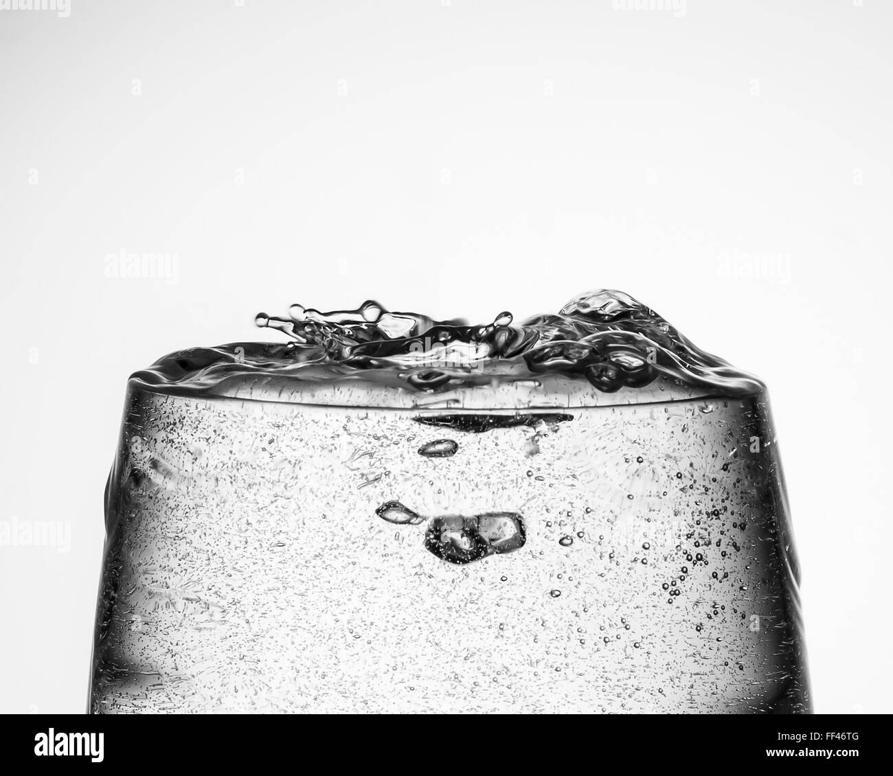 Glas mit einem Getränk in Gießen und Spritzwasser aus Stockfoto