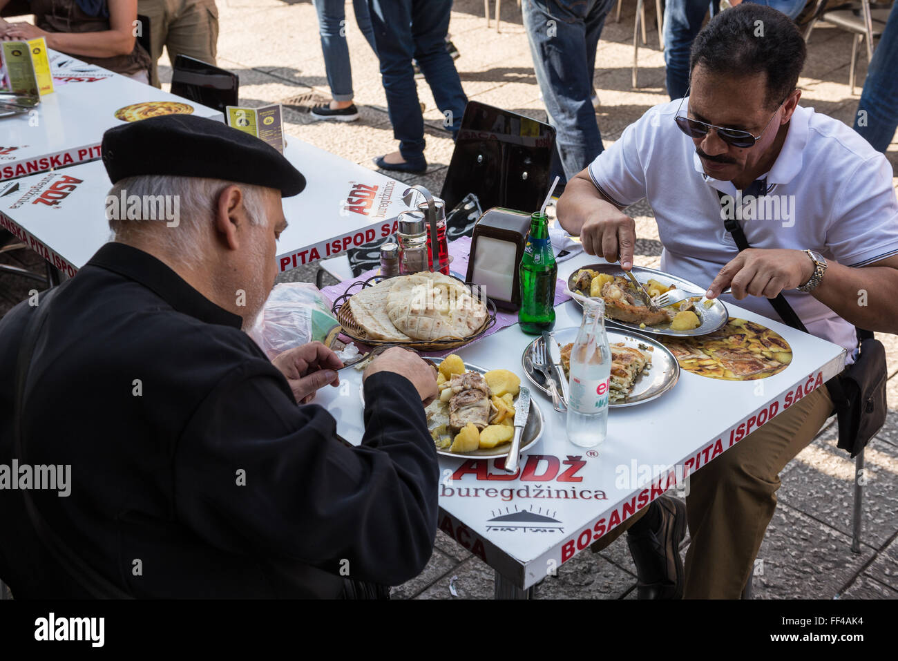 Zwei Männer essen Fleisch und Kartoffeln in kleine Restaurant im historischen Viertel Bascarsija in Sarajevo, Bosnien und Herzegowina Stockfoto