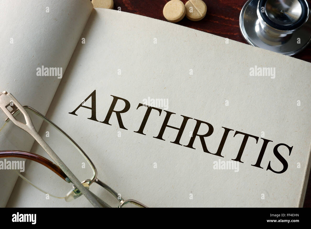 Buchen Sie mit Diagnose Arthritis und Pillen. Medizinisches Konzept. Stockfoto