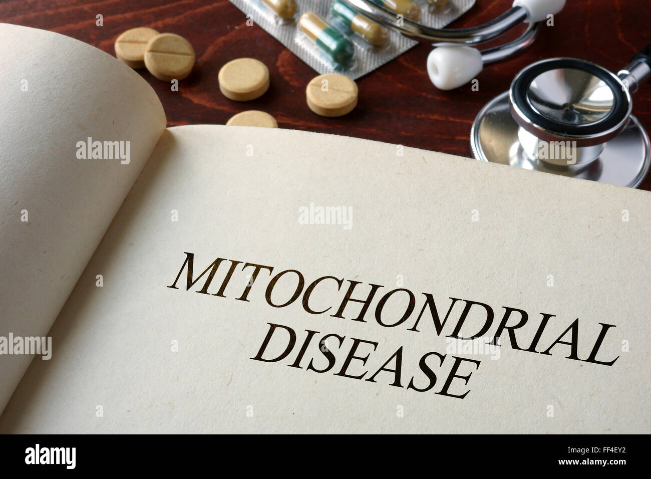 Buchen Sie mit mitochondrialen Erkrankungen Diagnose und Pillen. Medizinisches Konzept. Stockfoto