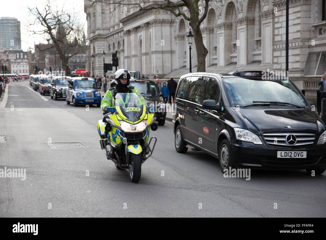 London, UK. 10. Februar 2016. Ein Polizei-Motorradfahrer sorgt dafür, dass schwarzes Taxi Taxifahrer in Whitehall bewegt während der frühen Stadien der Bummelstreik Protest. Bildnachweis: Mark Kerrison/Alamy Live-Nachrichten Stockfoto