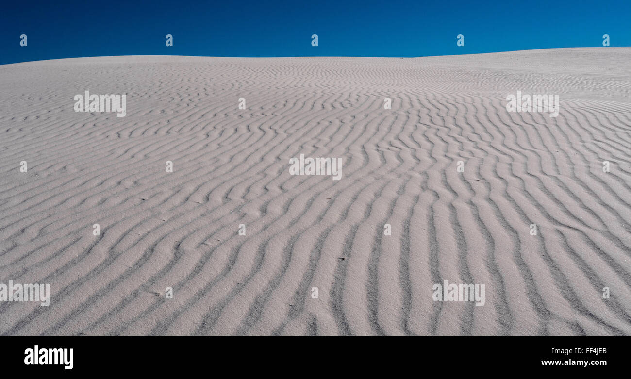 Texturen und Muster des White Sands National Park unter blauem Himmel Stockfoto