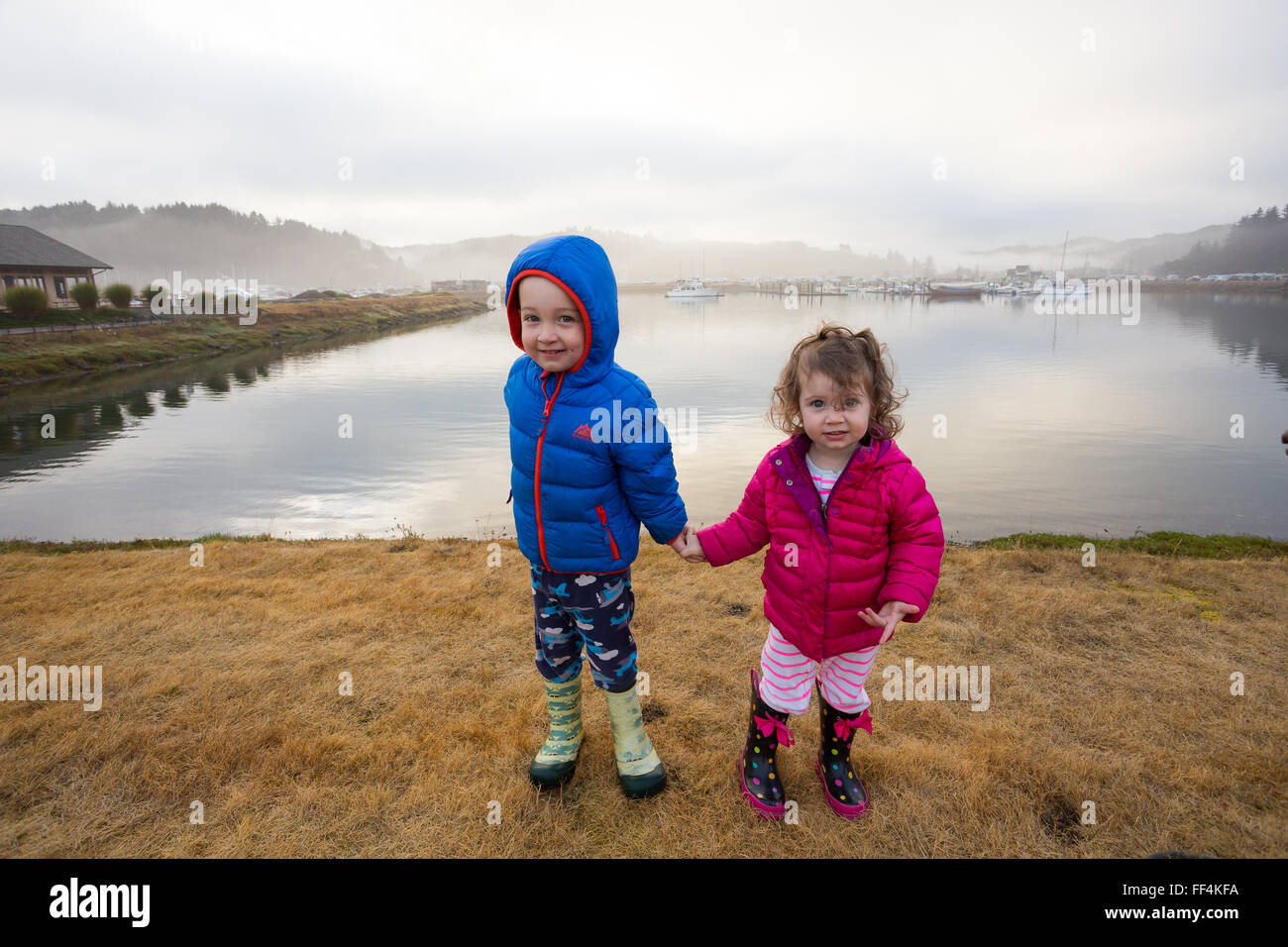 Bruder und Schwester, die Hand in Hand in diesem Geschwister Porträt zweier Menschen in Winchester Bay Oregon. Stockfoto