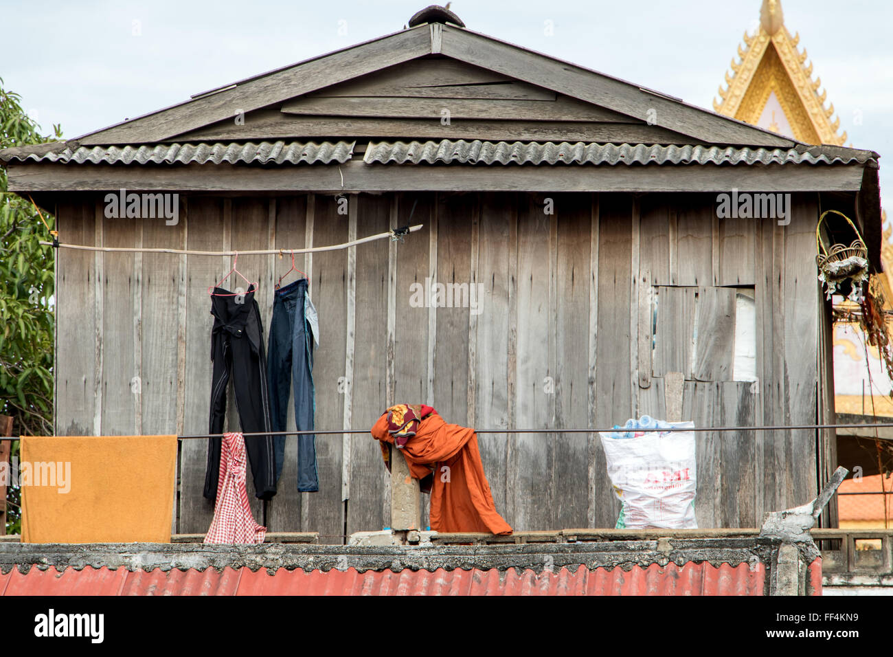 Zivilkleidung mit einer Kutte setzt auf dem Dach der Wohnung in einem buddhistischen Tempel Stockfoto