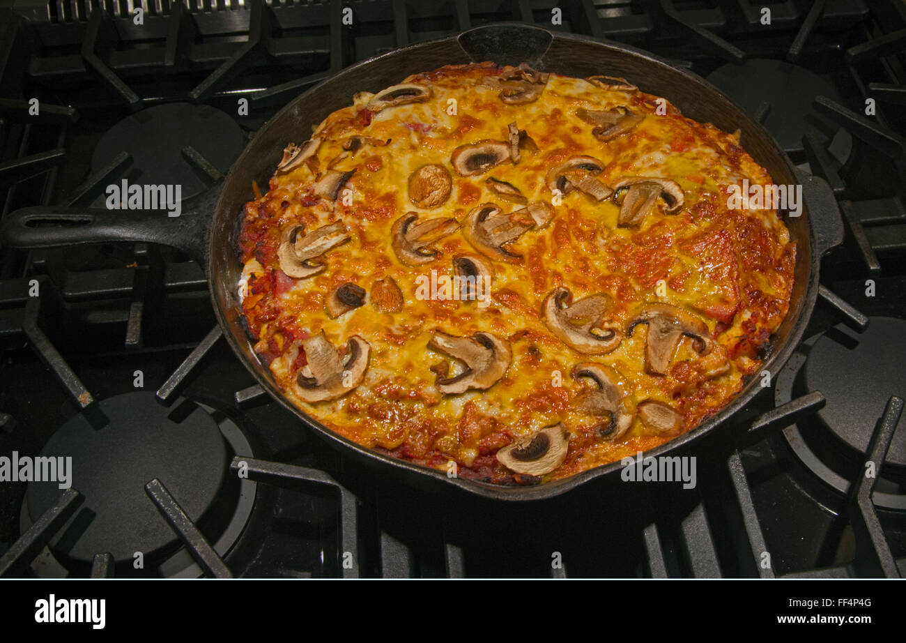 Pizza in einer gusseisernen Pfanne schwenken Stockfoto