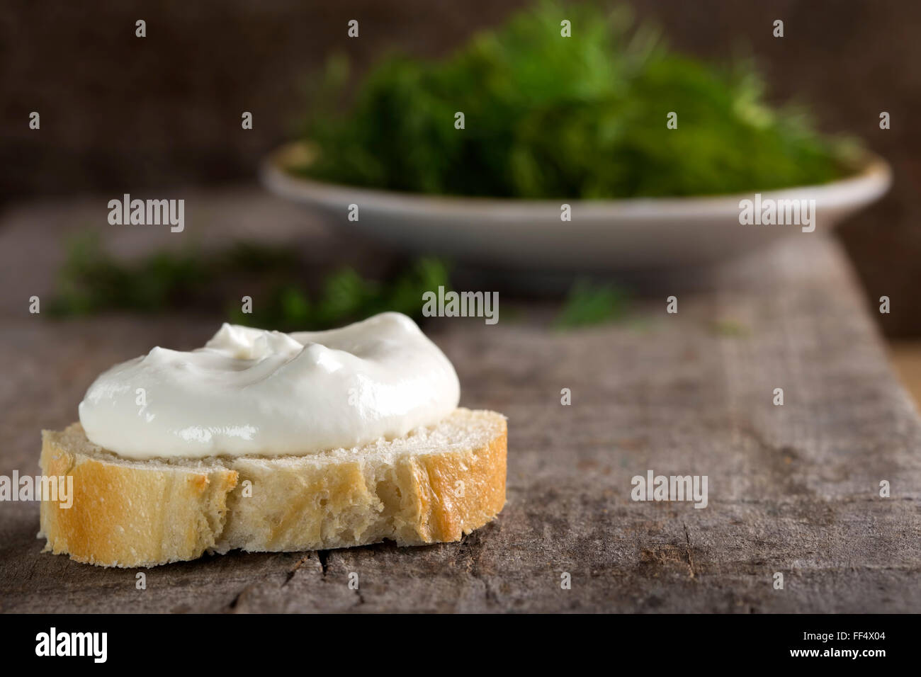 Gesunde Bio ganze Korn-Bagel mit Frischkäse über hölzerne Hintergrund Stockfoto