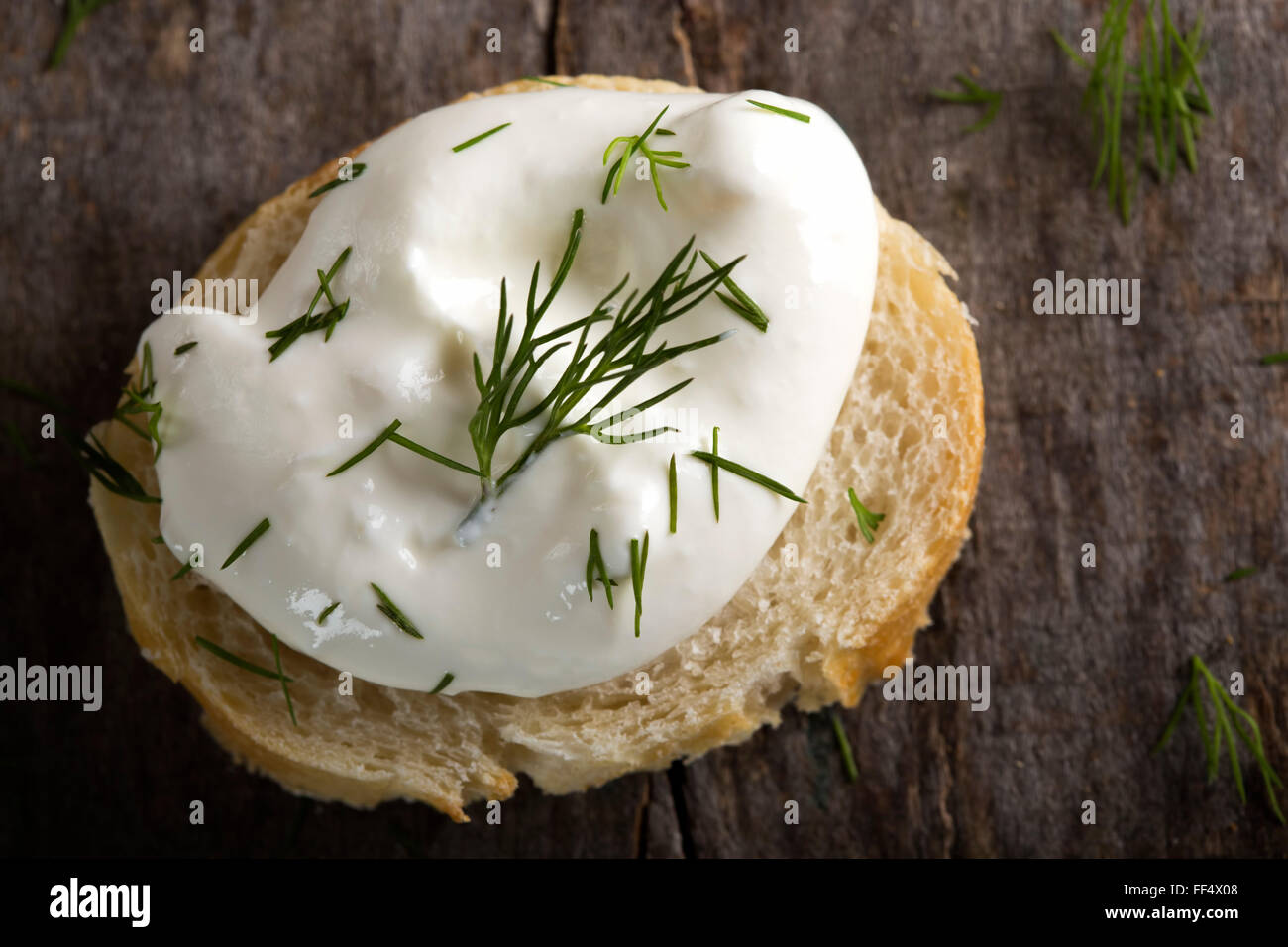 Brot mit Frischkäse über hölzerne Hintergrund Stockfoto