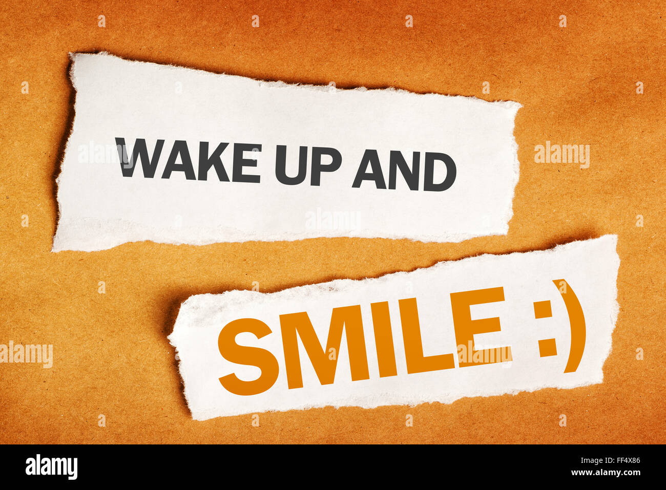 Wachen Sie auf und Lächeln Sie motivierende Botschaft auf einem Stück Papier Stockfoto