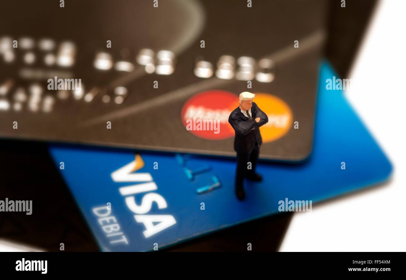 Eine Debit- und Kreditkarten-hautnah mit einer Miniatur Figur stehend verschränkten Armen. Stockfoto