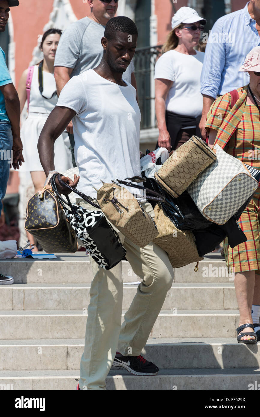 Ein afrikanischer Einwanderer illegale Straßenhändler verkaufen gefälschte  Damen Handtaschen wie Fendi, Gucci und Prada für Touristen in einem  Stockfotografie - Alamy