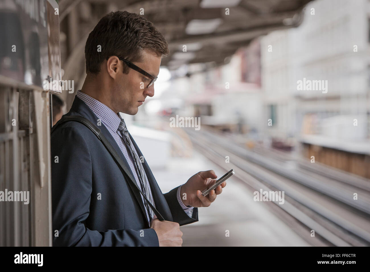 Ein Arbeitstag. Geschäftsmann in Arbeitsanzug und Krawatte hält eine Tasse Kaffee auf einem Bahnsteig. Stockfoto