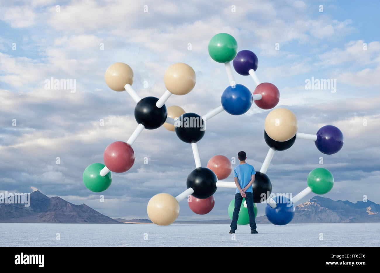 Ein Teenager auf der Suche nach oben auf eine große molekulare Struktur über ihn in der Luft. Stockfoto