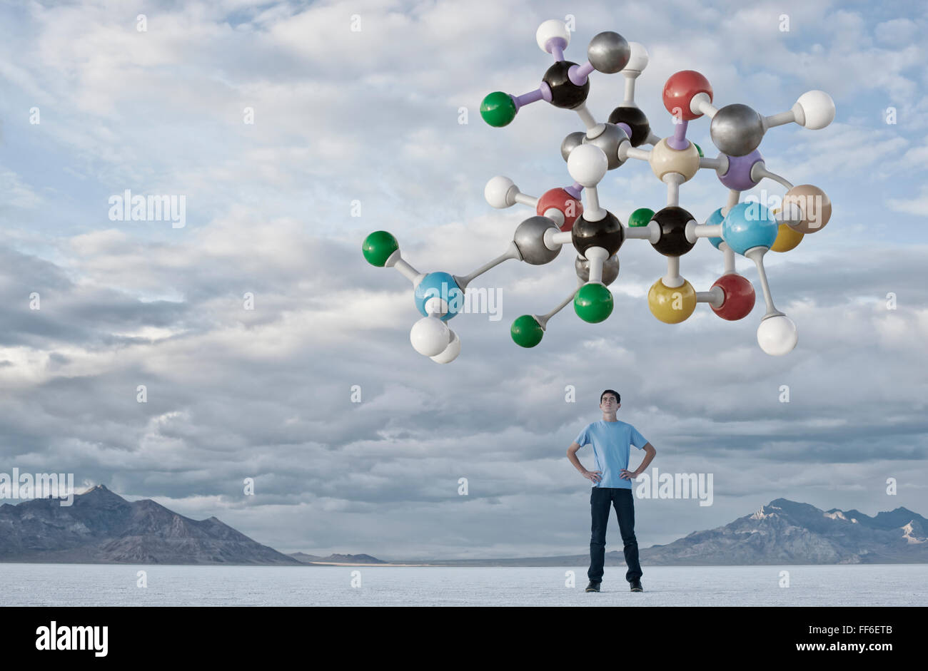 Ein Teenager auf der Suche nach oben auf eine molekulare Struktur über ihn in der Luft. Stockfoto