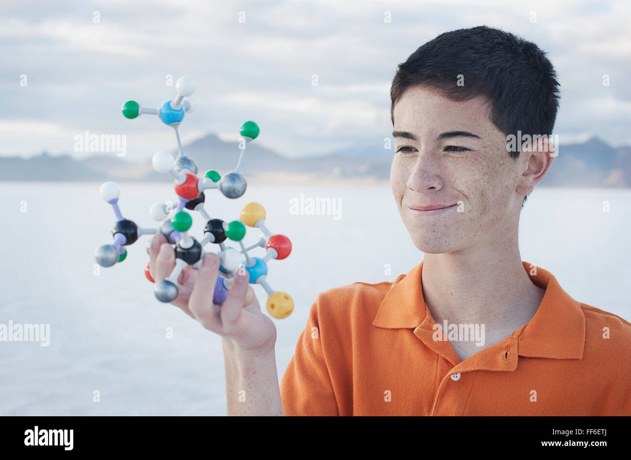Ein Teenager halten ein molekulares Modell in der Hand, mit verschiedenen farbigen Kugeln, die aus Atomen. Stockfoto