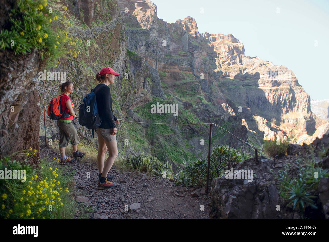 Zwei Frauen werfen Sie einen Blick aus einer Wandern Wanderung auf Felsvorsprüngen und Tunnel führt vom Mount Arieiro zum Mount Ruivo auf Madeira Stockfoto