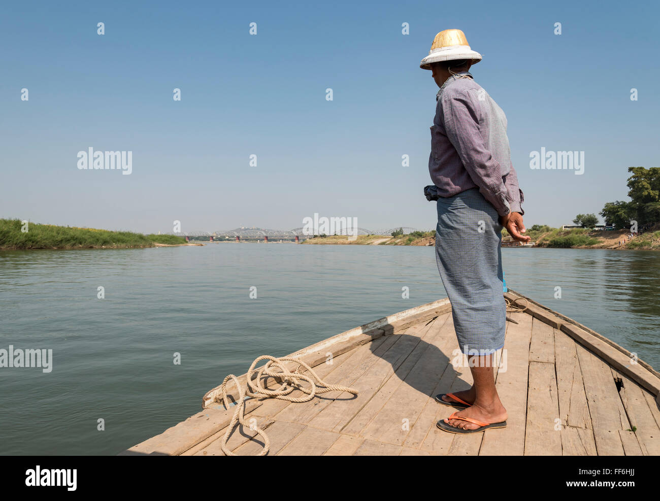 Bootsmann auf Inwa ferry mit Irrawaddy Brücken im Hintergrund, Birma (Myanmar) Stockfoto