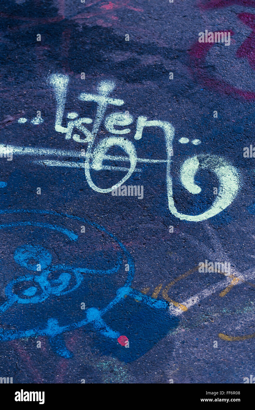 Graffito auf dunkelblauem Hintergrund des Wortes hören Stockfoto