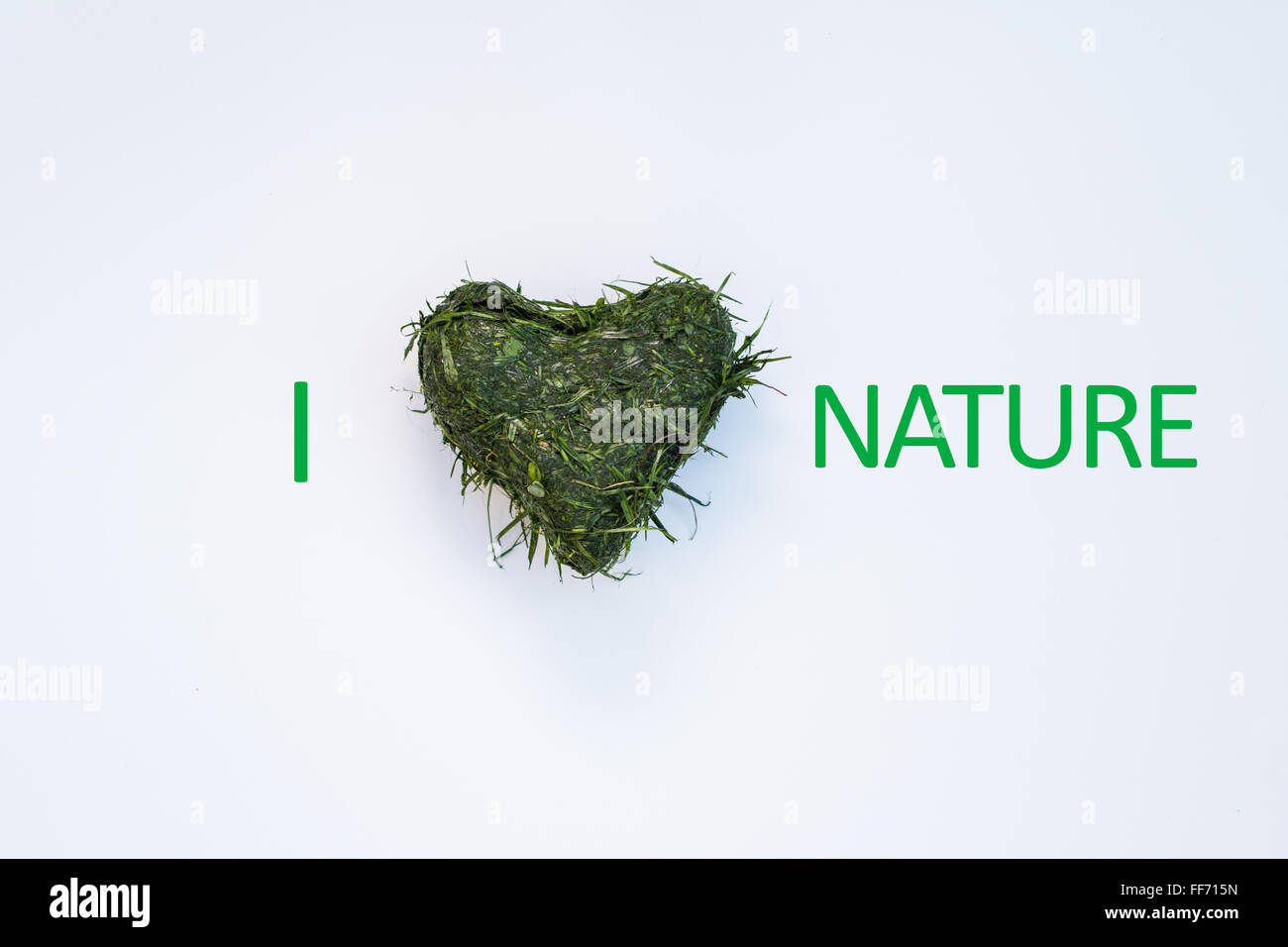 Herzform aus frischem Grasschnitt mit "Ich Liebe / Herz Natur" Grafik auf weißem Hintergrund Stockfoto