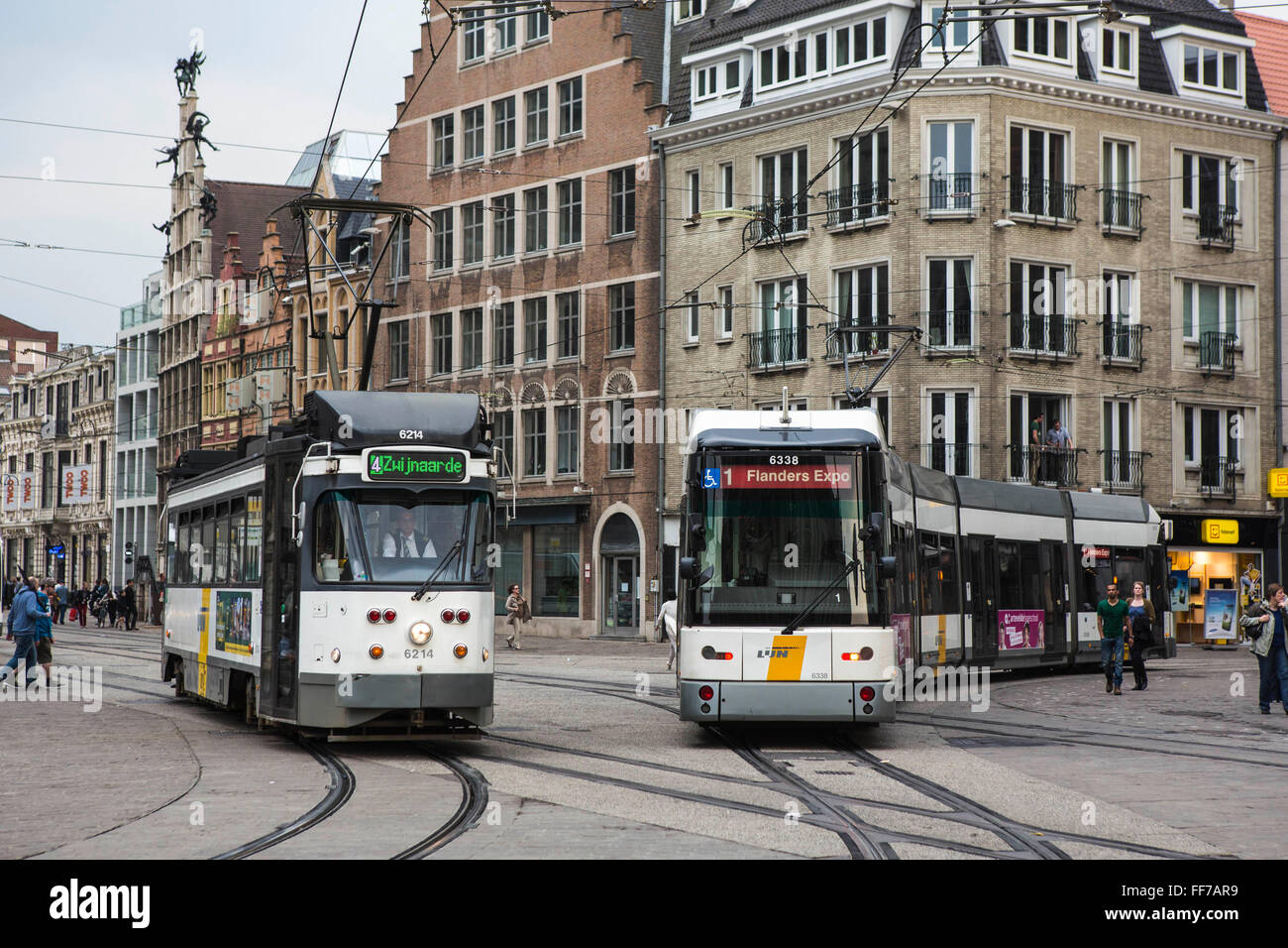 Zwei De Lijn Straßenbahnen fahren Sie entlang der Ghent Straßenbahnnetzes in zentralen Gent, Belgien.  Die Straßenbahn auf der linken Seite ist Route 4 zu Zwi Jnaarde, die Straßenbahn auf der rechten Seite ist die Route 1, Flanders Expo. De Lijn haben vor kurzem neue moderne Straßenbahnen (Straßenbahn rechts) die 20 % weniger Strom und sind ein nachhaltiger Transport entwickelt. Stockfoto