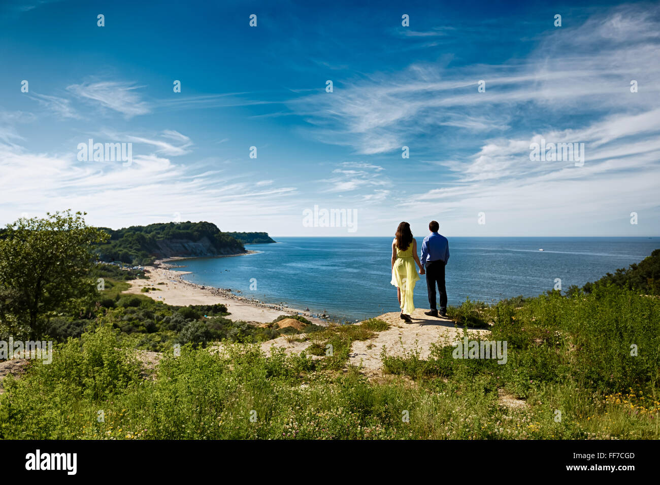 Liebespaar auf einer Klippe auf dem Hintergrund des Ozeans Stockfoto