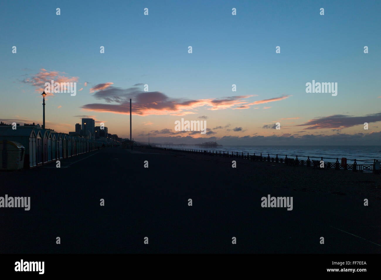 Dawn Wolken über Meer und Strand Hütten, entfernten Stadt in der Silhouette, i360, Hove, Sussex, UK Stockfoto