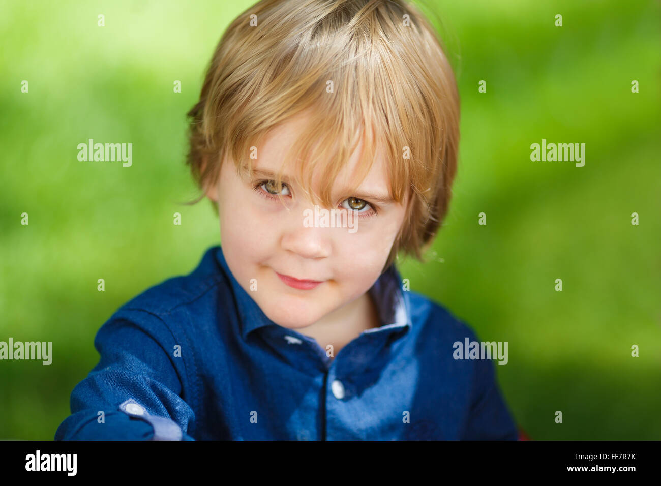 Porträt eines kleinen niedlichen Jungen auf grünem Hintergrund Stockfoto