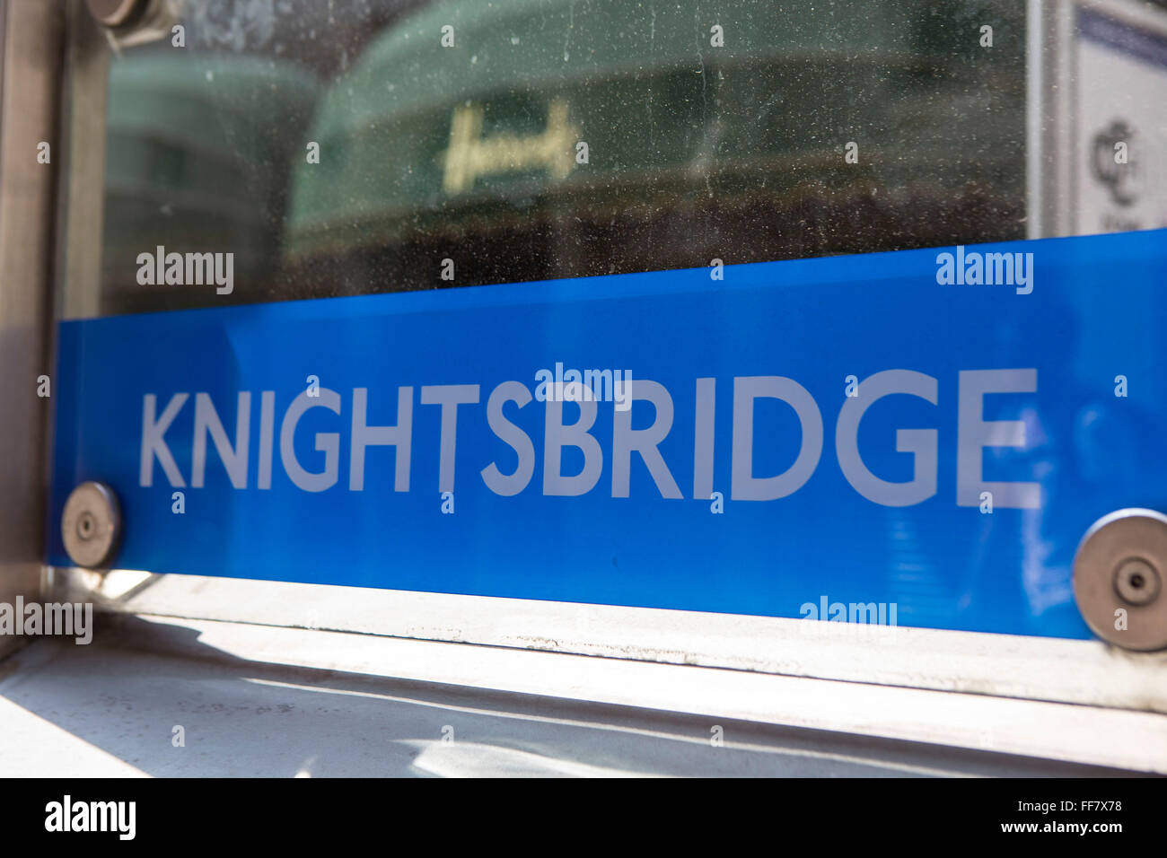 Knightsbridge London Underground Schild vor dem Eingang der Tube Station mit der Welt berühmten Harrods Shop Markise im Hintergrund, London, Vereinigtes Königreich. Stockfoto