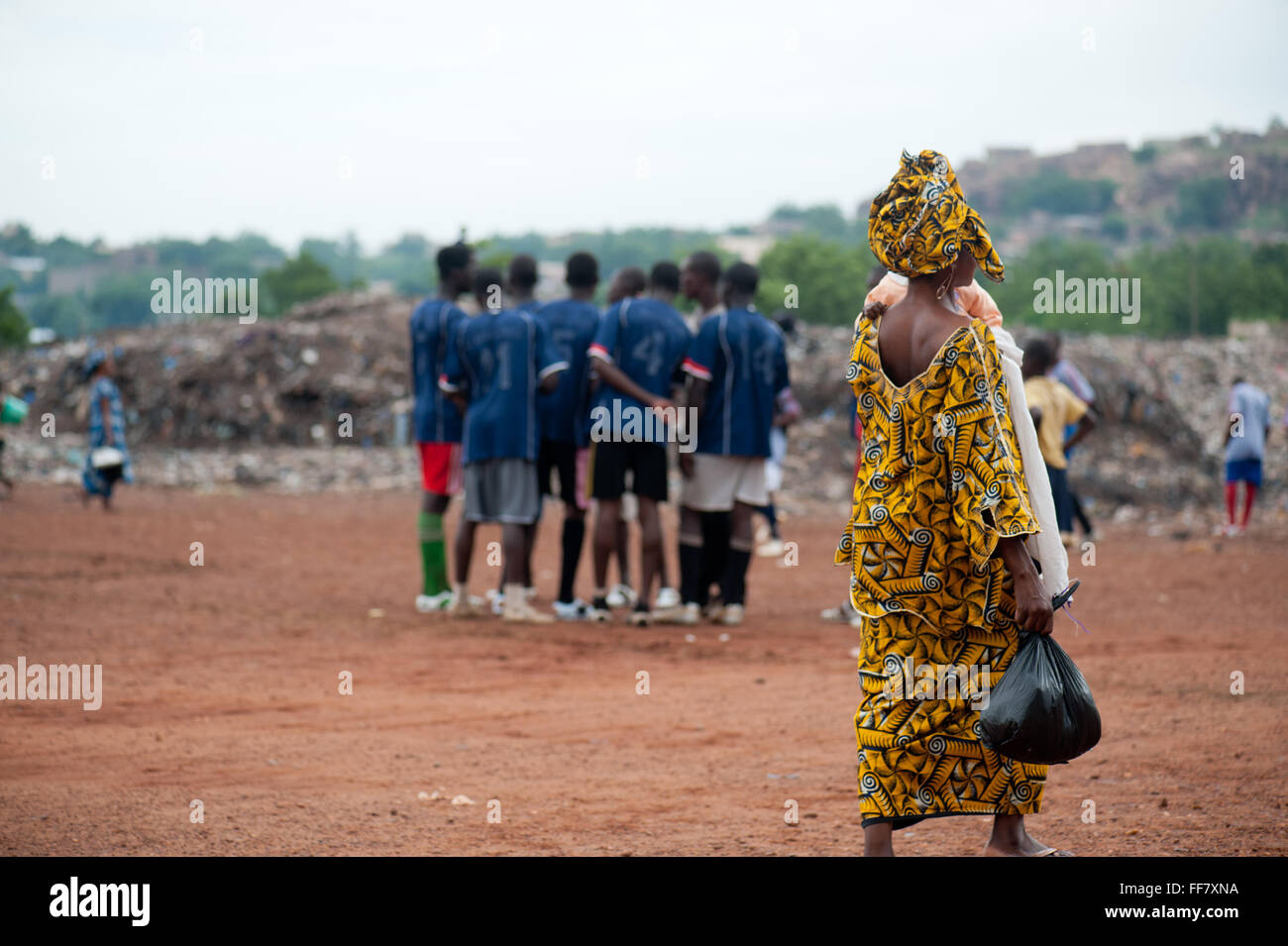 Mali, Afrika - schwarze Frau Wanderungen in einer Fußballmannschaft in der Nähe von Bamako. Müllhalde Stockfoto