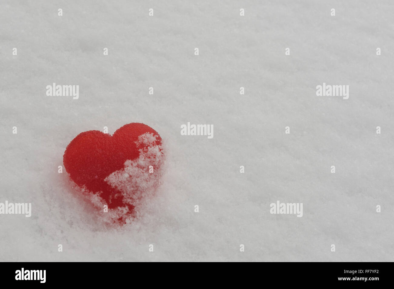 Rotes Zuckerherz im Schnee Stockfoto