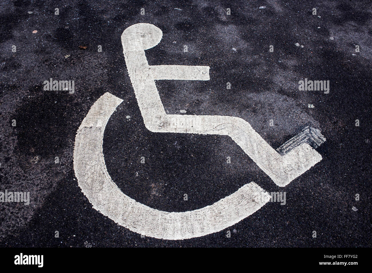 Rollstuhl-Abbildung Schablonen in weiße Linien auf Asphalt als ein Zeichen für einen behinderten Parkplatz Middlesborough, England, UK. Stockfoto