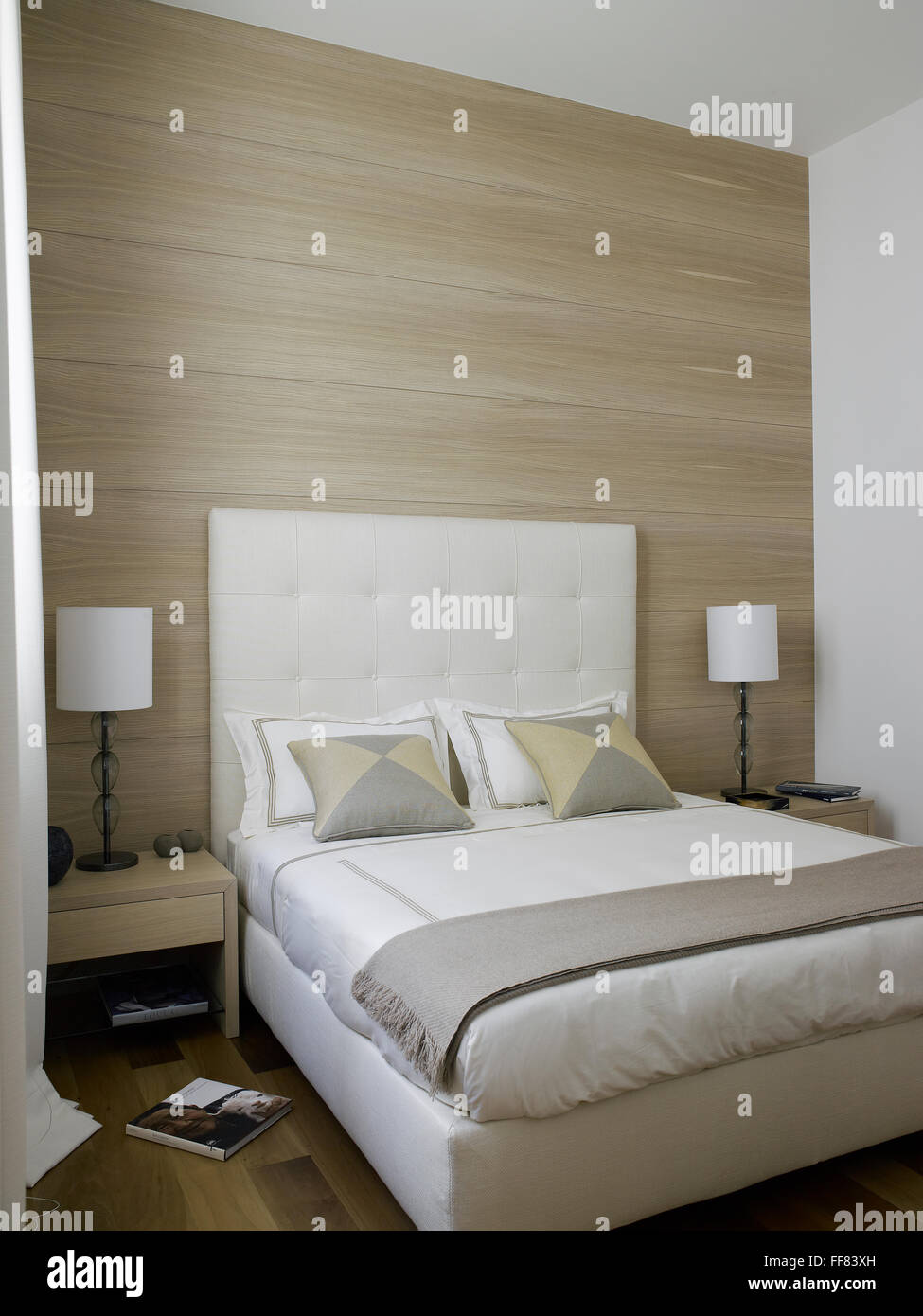 Innen ein elegantes Schlafzimmer mit Nachttisch und einem Buch auf dem Boden Stockfoto