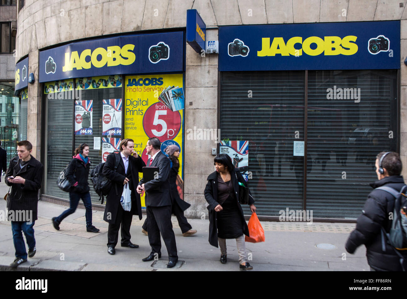London City Arbeitnehmer gehen vorbei an einem Fotogeschäft Jacobs, die vor kurzem in der Nähe von Bank, London, Vereinigtes Königreich geschlossen hat.  Jacobs, Digital Foto, ein britisches Familienunternehmen, ging in die Verwaltung im Juni 2012.  Das Retail-Geschäft wurde 1939 gegründet, aber wurde ein Opfer der Konjunkturabschwächung, da gab es eine Verschiebung in Richtung Internet-basierte Händler zu kaufen. Stockfoto