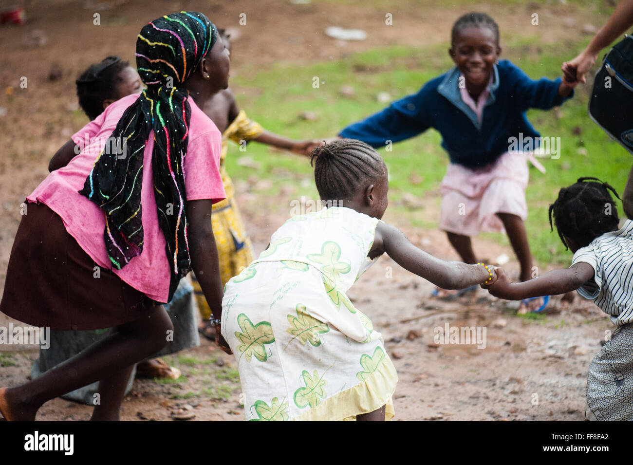 Mali, Afrika - kaukasische Mädchen Spaß in einem Ring um die rosey mit schwarzen afrikanischen Kindern in der Nähe von Bamako Stockfoto