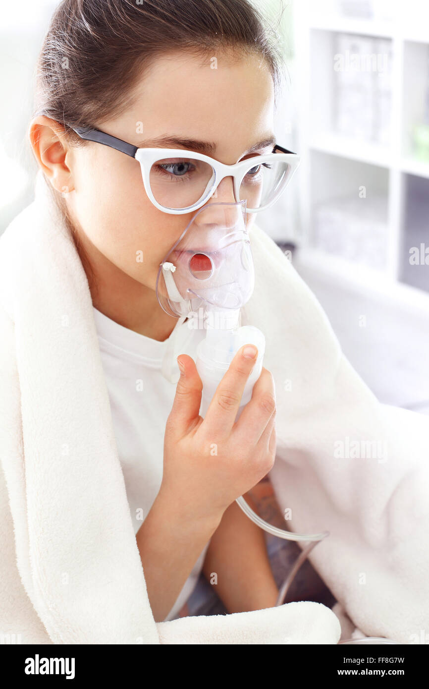 Das Mädchen in der Behandlung von etablierten Inhalation Maske einatmen Stockfoto