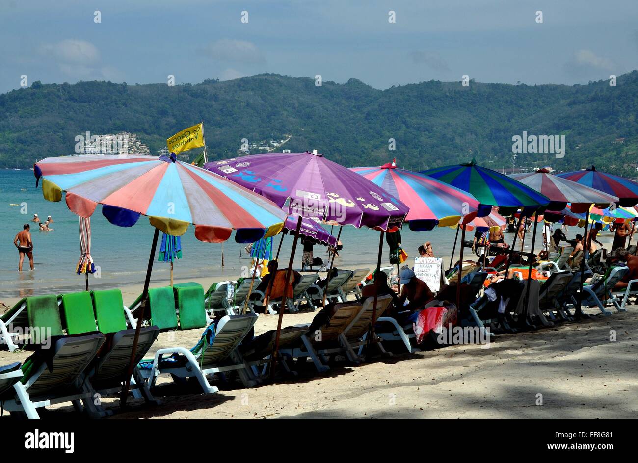 Phuket, Thailand: Bunten Sonnenschirmen und weißen Liegestühlen säumen den weißen Sandstrand von Patong Beach Stockfoto