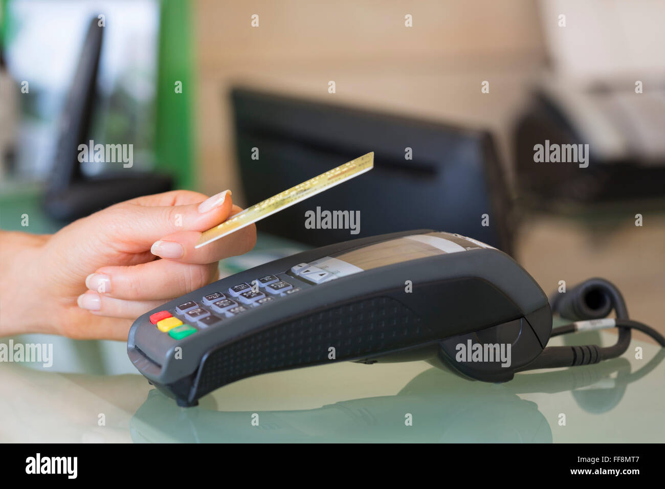 Frau mit NFC-Technologie auf Kreditkarte im Shop bezahlen Stockfoto