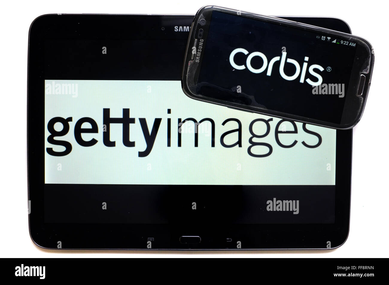 Die Nachrichtenagenturen Corbis und Getty Images auf den Bildschirmen der ein Tablet und Smartphone vor weißem Hintergrund fotografiert. Stockfoto