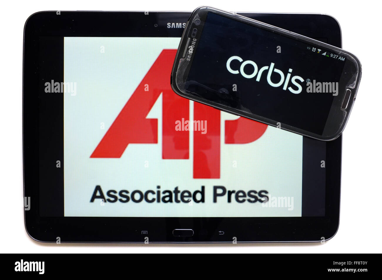 Die Nachrichtenagenturen AP und Corbis auf den Bildschirmen der ein Tablet und Smartphone vor weißem Hintergrund fotografiert. Stockfoto